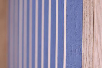 Nahaufnahme der blau lasierten Holzlamellen mit Fugen neben Eichenrahmen – MOZ-Areal VR-Bank, Würzburg