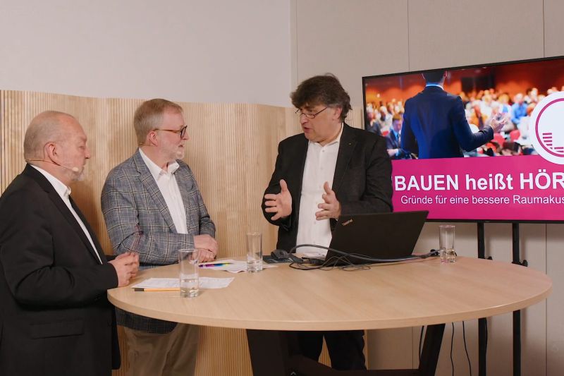 Martin Hepp, Prof. Schricker und ein Gast diskutieren an einem Tisch über Raumakustik