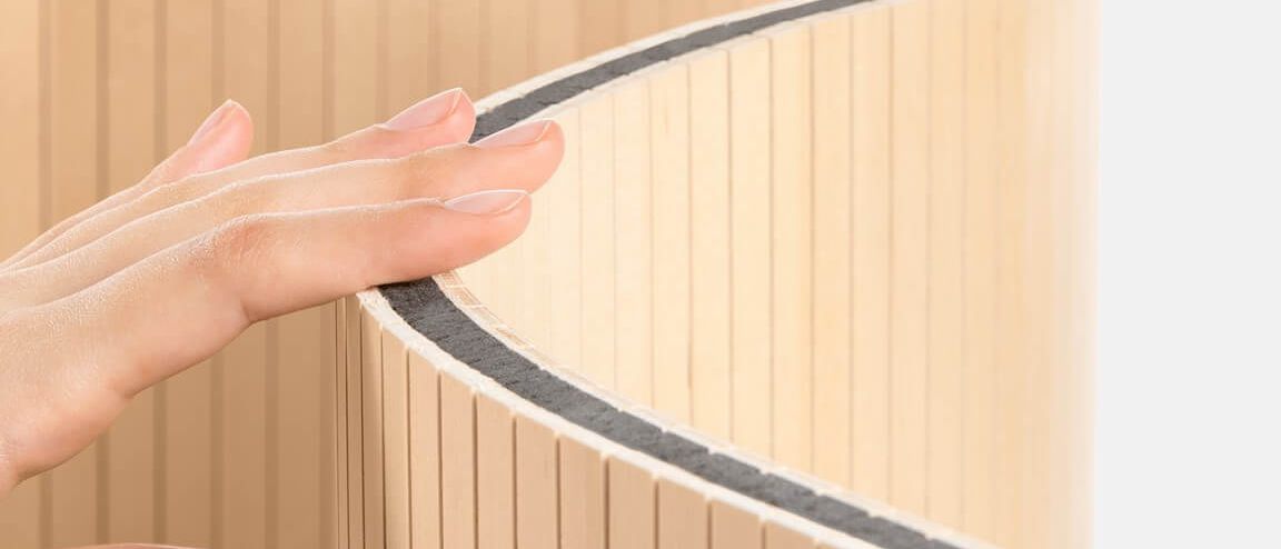 Eine Hand berührt den flexiblen Staudigel-Paravent mit schallabsorbierenden Eigenschaften.