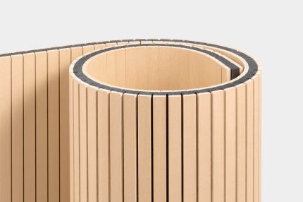 Der Staudigel-Paravent zeigt ein elegantes, geschwungenes Design aus schmalen Holzleisten.