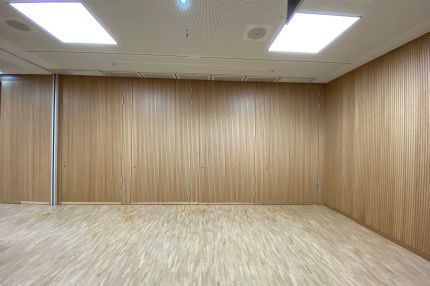 Stirnwand aus Eichen-Schlitzplatten mit integrierten Türen und Lochdecke – Technisches Rathaus Mannheim