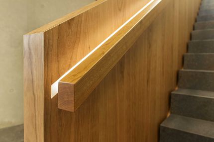 Detail des Holzhandlaufs mit eingelassenem Lichtband an der Treppenbrüstung – Deutsche Rentenversicherung, Würzburg