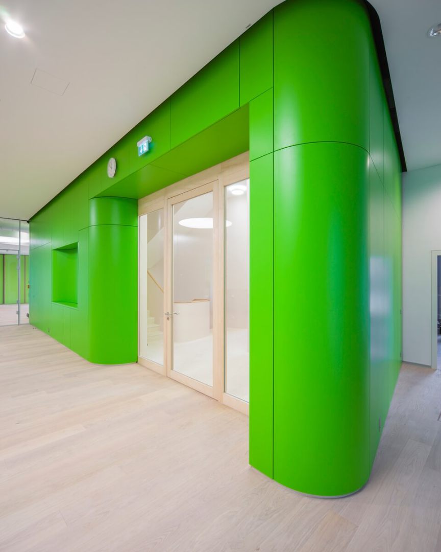 Grüne Staudigel-Wandverkleidungen schaffen eine moderne, einladende Atmosphäre.