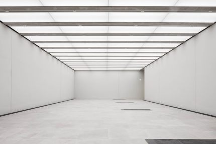 Ausstellungshalle mit Lichtdecke, weißen Wänden und Steinboden – James-Simon-Galerie, Berlin