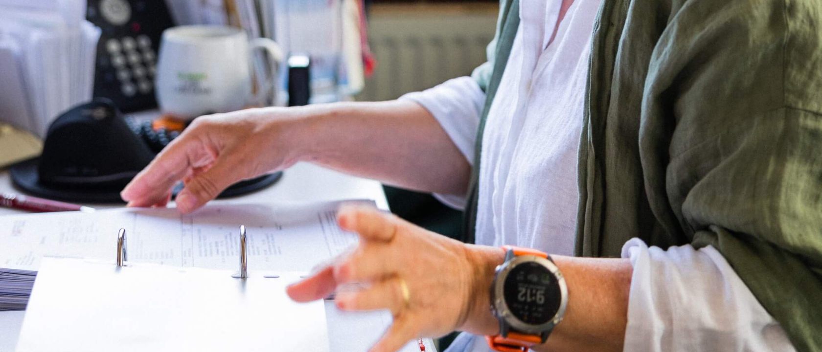 Eine Person durchblättert Dokumente am Schreibtisch bei Staudigel. | © Staudigel GmbH