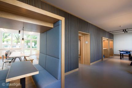 Sitzkabine an der Lamellenwand mit Blick in die Cafeteria mit Fensterfront – MOZ-Areal VR-Bank, Würzburg
