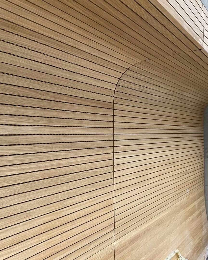 Gerundete Wand-Decken-Verkleidung aus Eichen-Schlitzplatten an Betonwand – Technisches Rathaus Mannheim