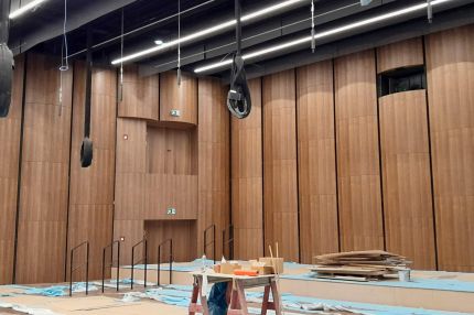 Seitenansicht des Saals im Bau mit Holzfurnier-Wandverkleidung und Wandnischen – Beethovenhalle Bonn