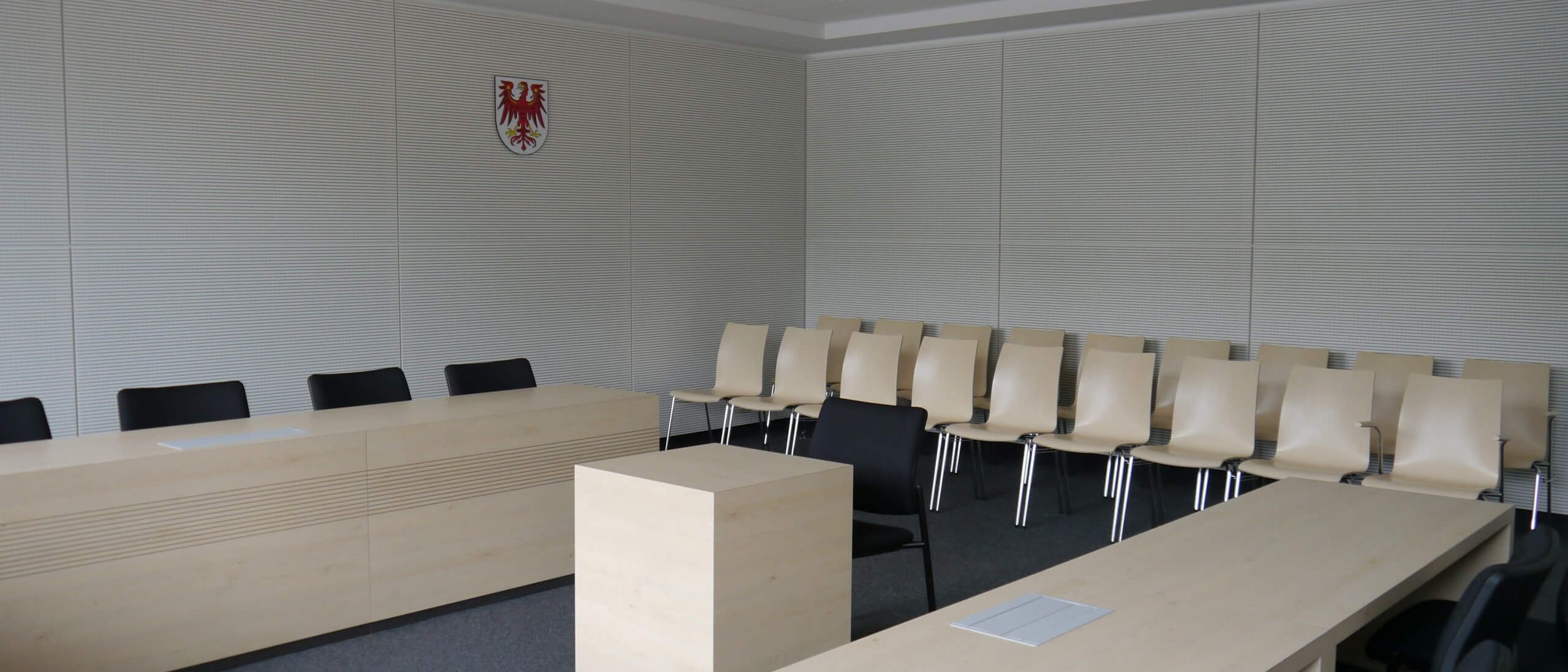 Sitzungssaal mit weißer Schlitzplatten-Wandverkleidung und Landeswappen – Sparkasse Spree-Neiße, Cottbus