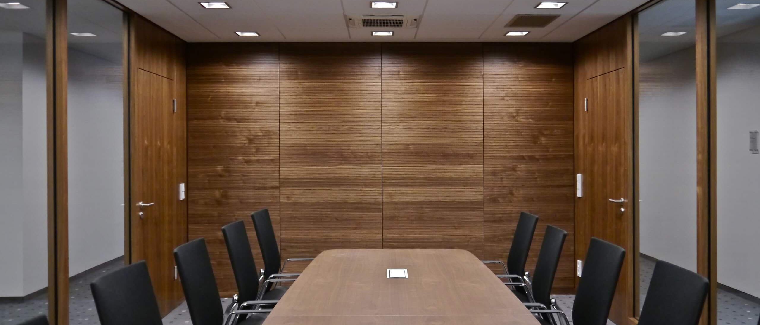 Besprechungsraum mit Nussbaum-Wandverkleidung, Glaswänden und langem Tisch – Sparkasse Spree-Neiße, Cottbus