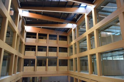 Frontalblick ins Atrium mit furnierten Fensterreihen und Lichtbändern unter dem Dach – IHK Nürnberg