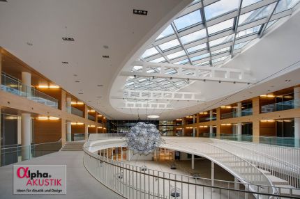 Halle unter ovalem Glasdach mit hängender Skulptur und holzverkleideten Galerien – Europäisches Patentamt