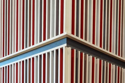 Detail der Lamellenverkleidung an einer Stützenecke mit roten und grauen Feldern – Mensa Würzburg