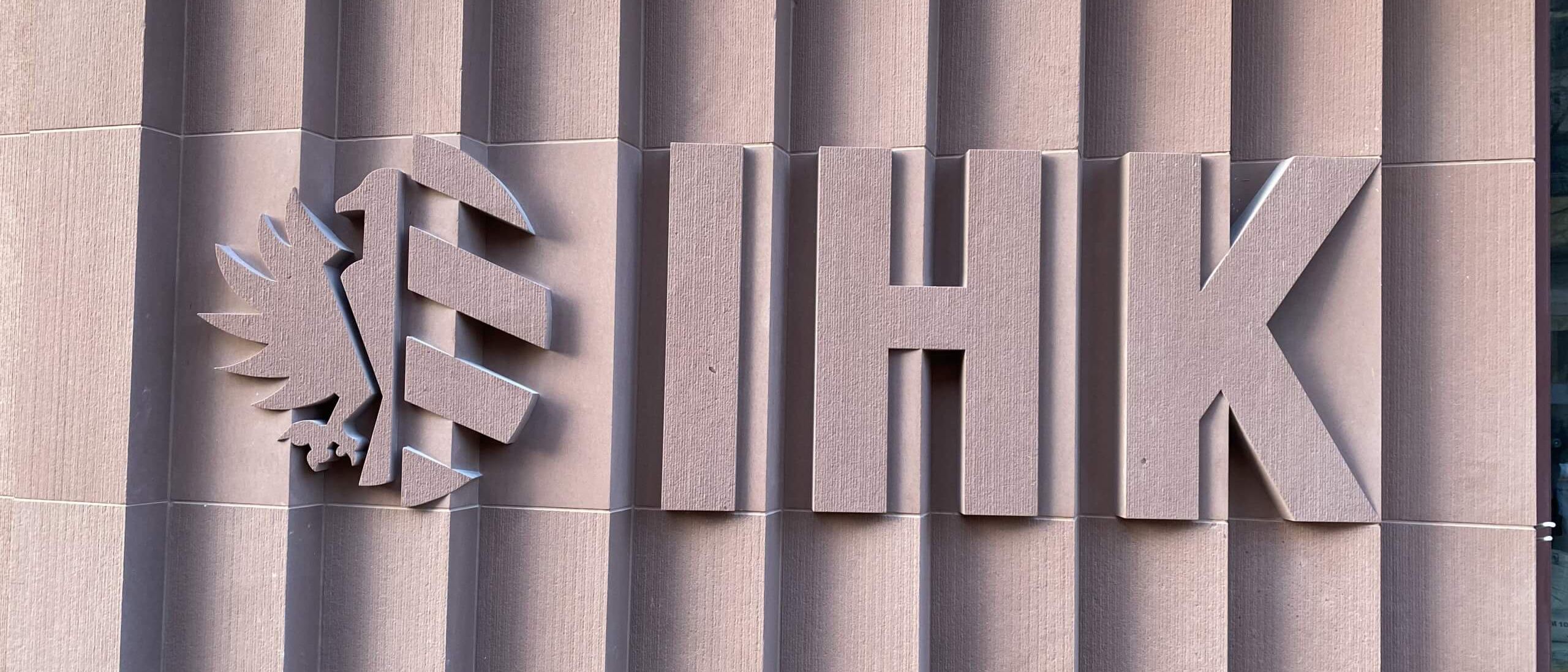 Fassade aus gefalteten Sandsteinplatten mit IHK-Schriftzug und Adlerlogo – IHK Nürnberg