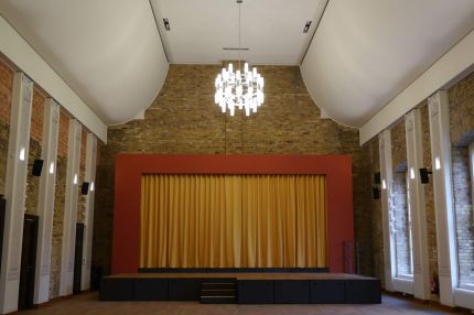 Frontalblick auf die Bühne im Festsaal mit geschwungener heller Decke – Neues Schloss Bad Muskau