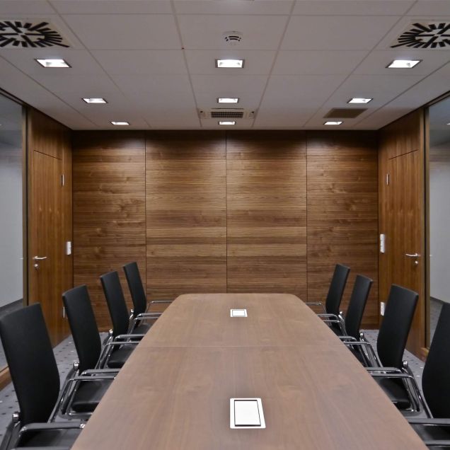 Besprechungsraum mit Nussbaum-Wandverkleidung, Glaswänden und langem Tisch – Sparkasse Spree-Neiße, Cottbus