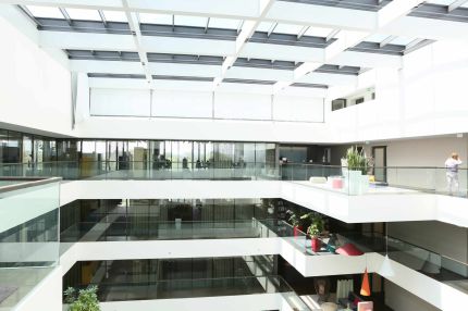 Lichthof mit Glasdach, weißen Galerien und Glasbrüstungen – AEB-Zentrale, Stuttgart