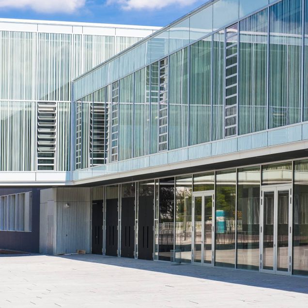Glasfassade mit vertikalen Lamellen und verglaster Eingangsfront am Innenhof – Gymnasium Oberursel