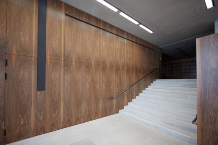 Foyer mit Steintreppe vor raumhoher Wandverkleidung in Nussbaum-Furnier – James-Simon-Galerie, Berlin