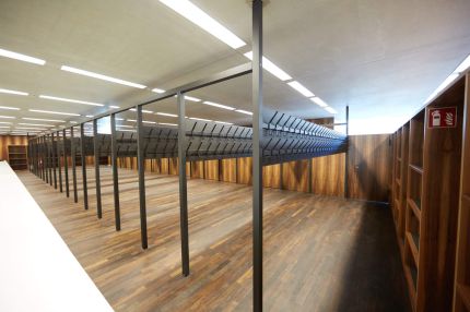 Garderobe mit Kleiderhakenreihen, Nussbaum-Wandverkleidung und Regalen – James-Simon-Galerie, Berlin