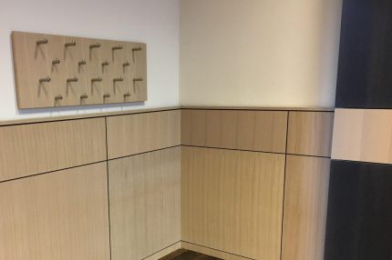 Raumecke mit Holz-Wandverkleidung in Brüstungshöhe und Garderobenleiste – Justizzentrum Bochum