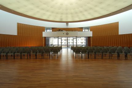 Saal mit Stuhlreihen und Holz-Wandverkleidung, Blick zur verglasten Front – IHK Potsdam