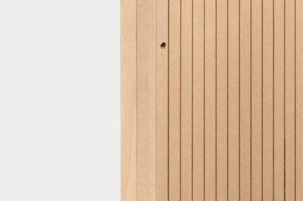 Ein flexibler Staudigel-Paravent mit vertikalen Lamellen aus hellem Holz.