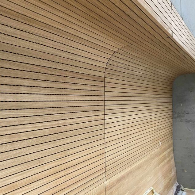Gerundete Wand-Decken-Verkleidung aus Eichen-Schlitzplatten an Betonwand – Technisches Rathaus Mannheim