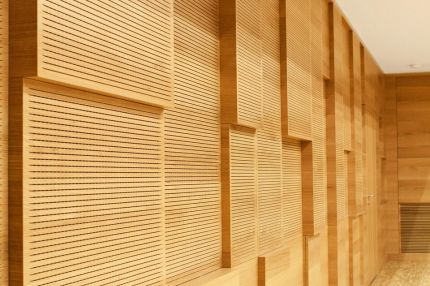 Schrägansicht der versetzt angeordneten Schlitzplatten aus Holz an der Saalwand – Musikschule Essenbach