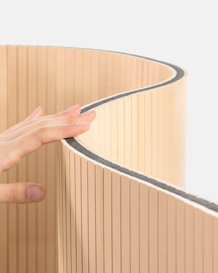 Eine Hand berührt den flexiblen Staudigel-Paravent mit schallabsorbierenden Eigenschaften.