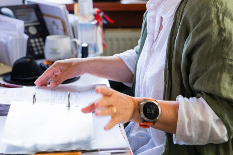 Eine Person durchblättert Dokumente am Schreibtisch bei Staudigel. | © Staudigel GmbH