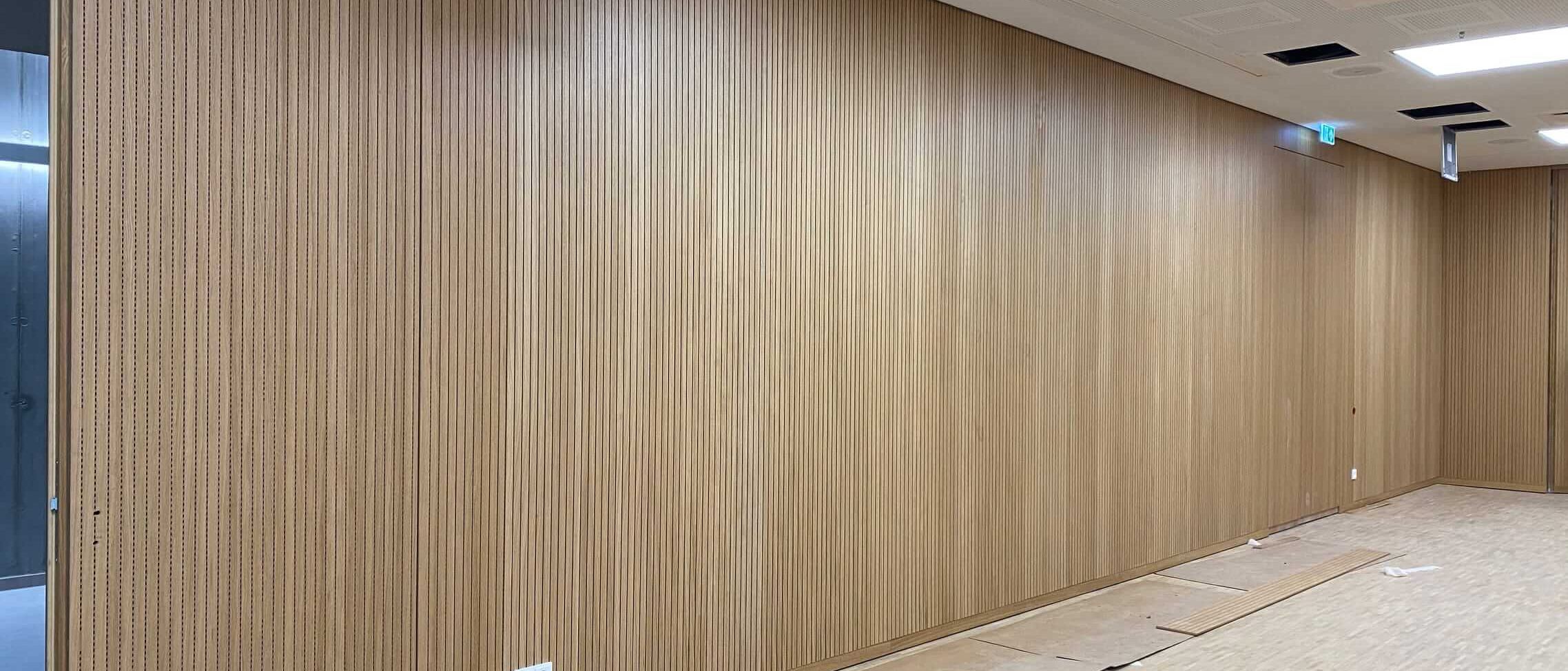 Saal mit Wandverkleidung aus Eichen-Schlitzplatten, Lochdecke und Parkett – Technisches Rathaus Mannheim