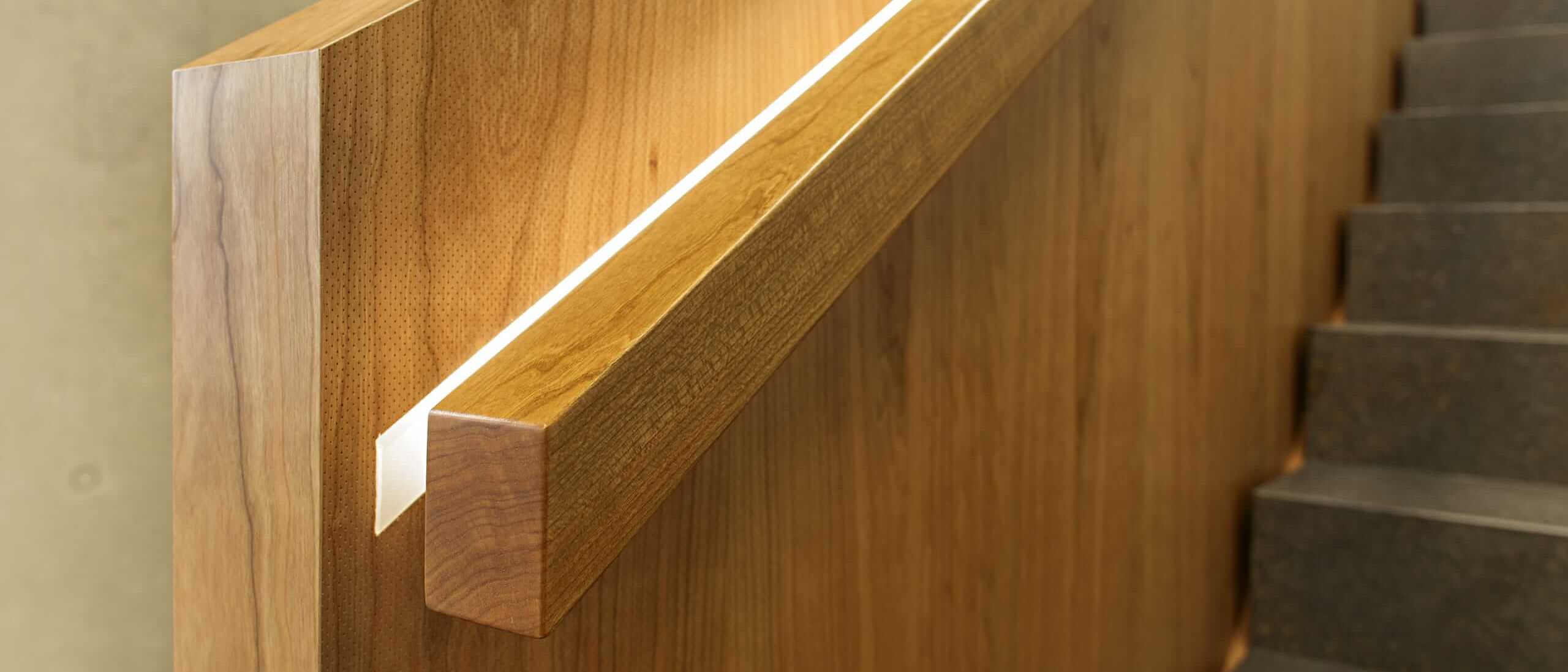 Detail des Holzhandlaufs mit eingelassenem Lichtband an der Treppenbrüstung – Deutsche Rentenversicherung, Würzburg