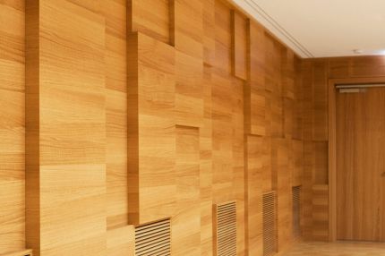 Holz-Wandverkleidung mit versetzten Feldern und Lüftungsgittern – Musikschule Essenbach