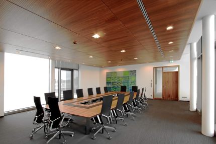 Konferenzraum mit Nussbaum-Decke, langem Tisch und grünem Wandbild – Sparkasse Spree-Neiße, Cottbus