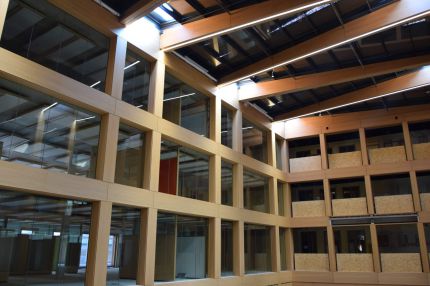 Atrium mit Lichtbändern in den Holzträgern und furnierter Glasfassade – IHK Nürnberg