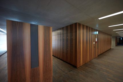 Schließfachblock mit Nussbaum-Furnier und Wandpaneel mit Akustikeinlage im Garderobenbereich – James-Simon-Galerie, Berlin