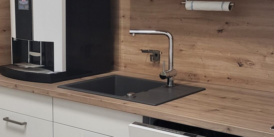 Moderne Teeküche mit einem eleganten Staudigel-Kaffeeautomat und stilvollen Möbeln.