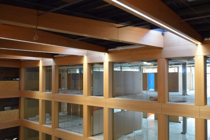 Atrium im Ausbau mit holzfurnierter Fensterrasterfassade und Lichtbändern in den Deckenträgern – IHK Nürnberg
