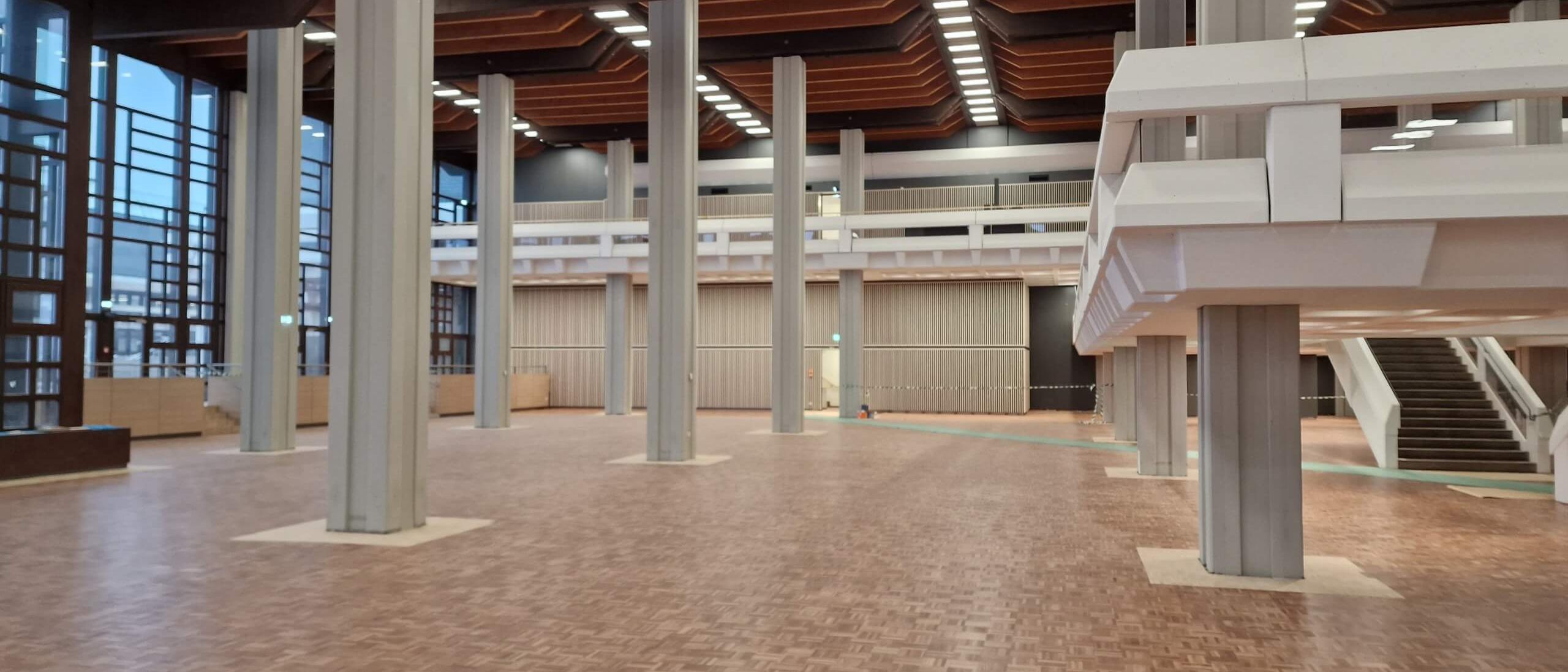 Speisesaal mit Stützen, Holzkassettendecke, Galerie und Treppe – Mensa Würzburg