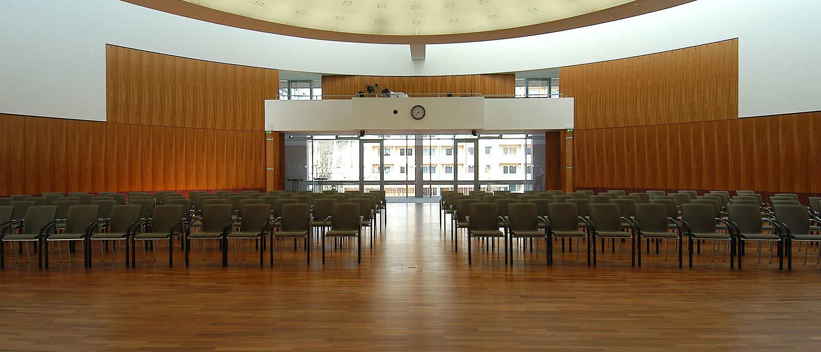 Saal mit Stuhlreihen und Holz-Wandverkleidung, Blick zur verglasten Front – IHK Potsdam