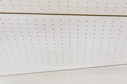 Detail der Deckenverkleidung aus weißen Lochplatten mit Fugen – Gymnasium Oberursel