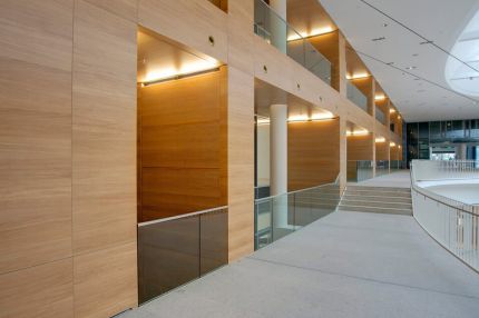 Galeriegang entlang großflächiger Holzwandverkleidung mit Lichtnischen – Europäisches Patentamt