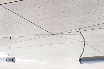 Lochplatten-Decke mit sternförmigen Fugen und abgehängten Röhrenleuchten – Gymnasium Oberursel