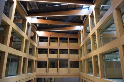 Atrium mit holzverkleideten Dachträgern und umlaufendem Fensterraster in Holzfurnier – IHK Nürnberg