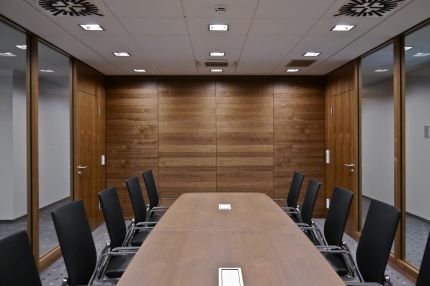 Besprechungsraum mit Nussbaum-Wandverkleidung, Glaswänden und langem Tisch – Sparkasse Spree-Neiße, Cottbus