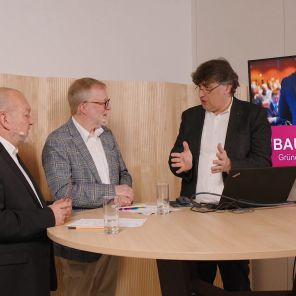 Martin Hepp, Prof. Schricker und ein Gast diskutieren an einem Tisch über Raumakustik
