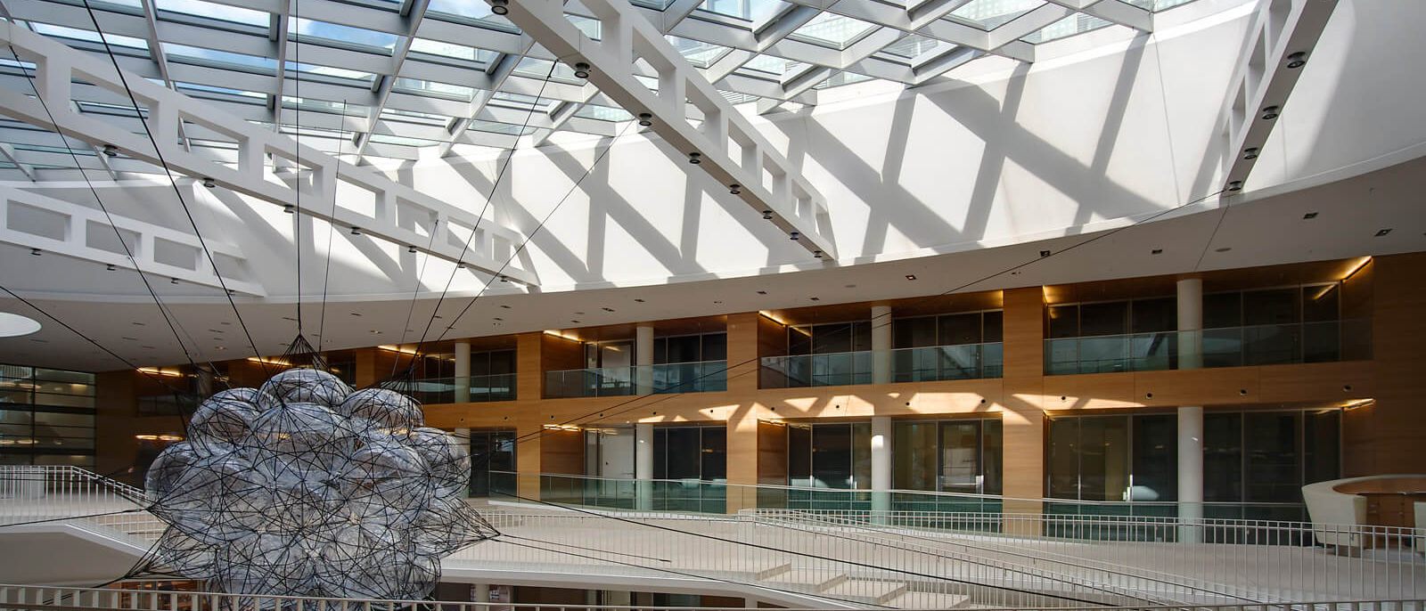 Glasdach mit weißen Stahlträgern über Halle und holzverkleideten Galerien – Europäisches Patentamt
