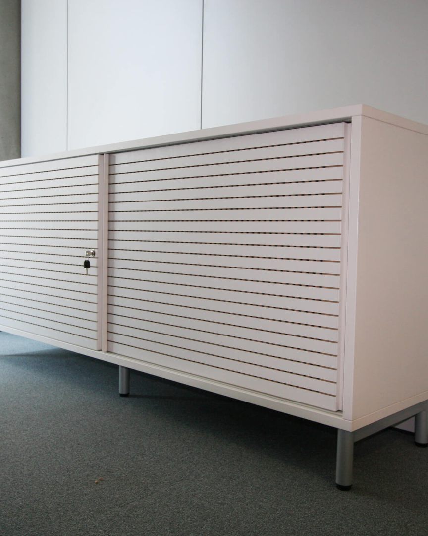 Ein modernes Sideboard von Staudigel mit geriffelter Oberfläche steht im hellen Raum.