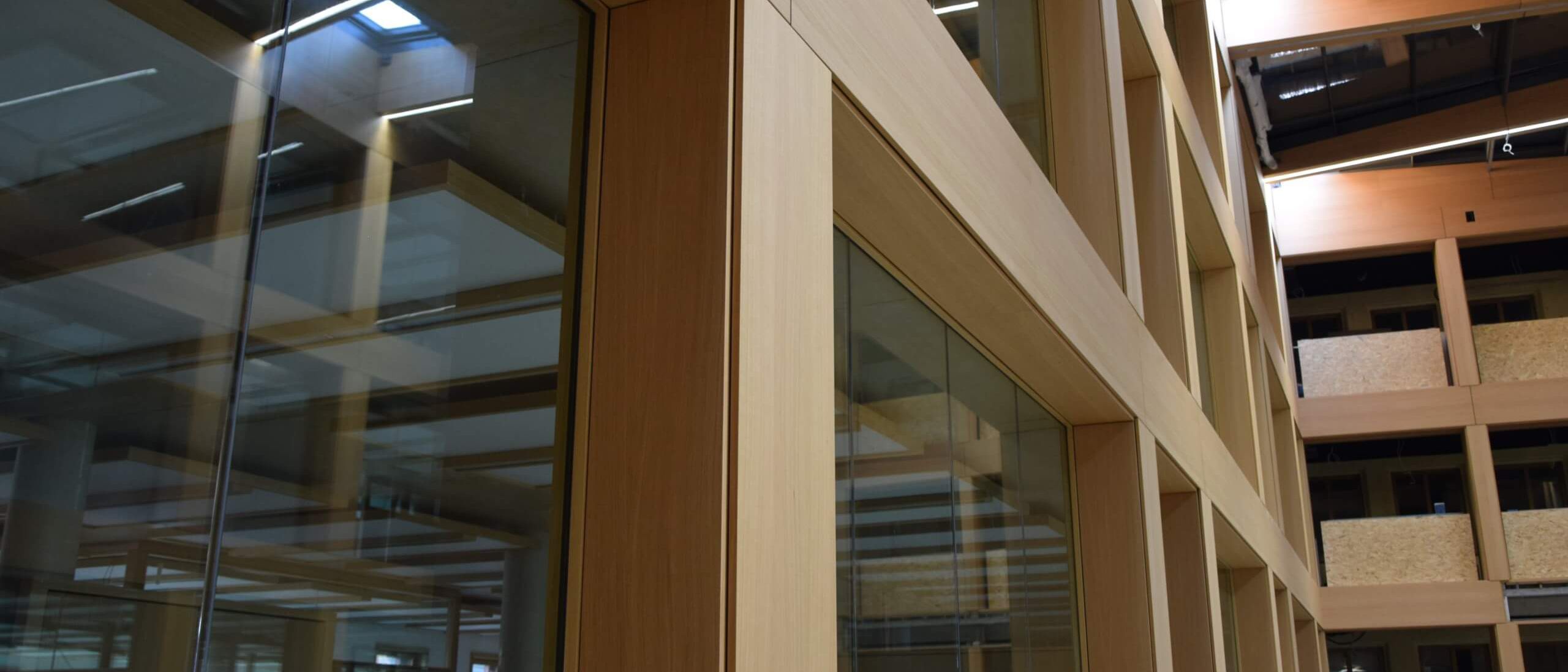 Blick entlang der holzfurnierten Fensterfront nach oben zu den Dachträgern – IHK Nürnberg